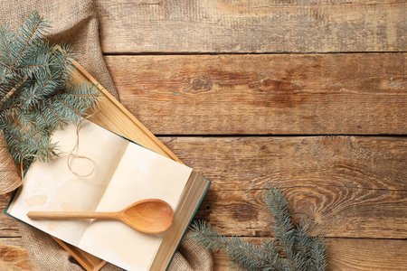 Blank recipe book with spoon and Christmas branches on wooden backgroundの写真素材
