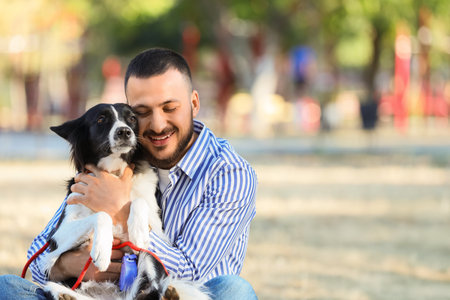 Young man hugging Border Collie dog outdoorsの写真素材
