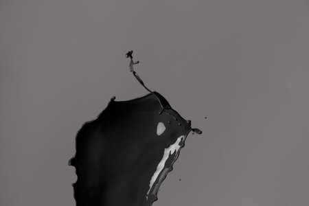 Splash of black paint on dark backgroundの写真素材
