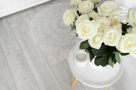 Vase with white roses on table in bathroom, closeupの写真素材