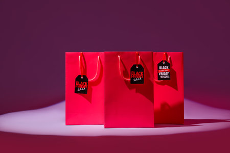 Shopping bags with tags on pink background. Black Friday saleの写真素材