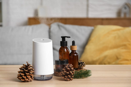Air humidifier with essential oils and pine cones on table in room