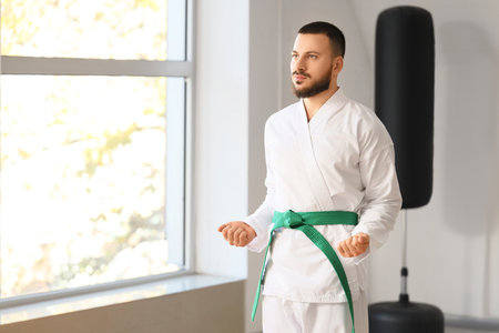 Man with green belt practicing karate in dojoの写真素材