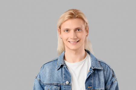 Young blonde man smiling on light backgroundの写真素材