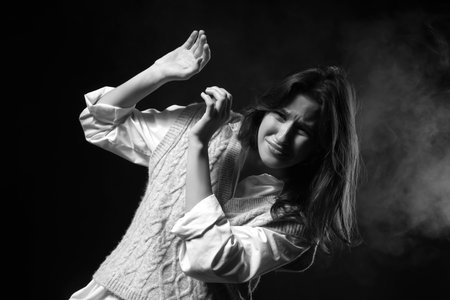 Scared young woman on black backgroundの写真素材