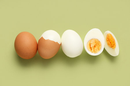 Row of fresh boiled eggs on green backgroundの写真素材