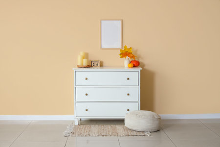 Interior of room with commode and autumn leaves in vase