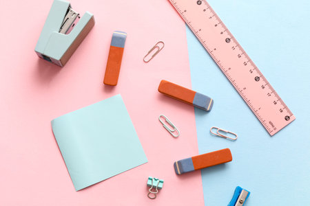 Erasers with stationery on color background