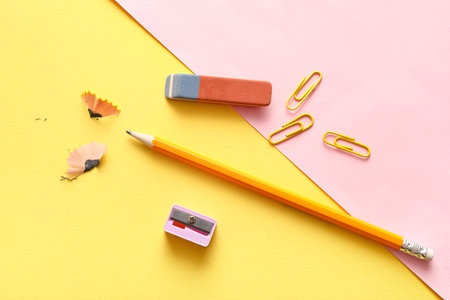 Eraser with sharpener, pencil, and paperclips on color backgroundの写真素材
