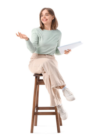 Young actress with film script sitting on white backgroundの写真素材