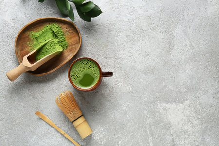 Composition with cup of matcha tea and green twig on gray grunge backgroundの写真素材