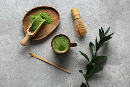 Composition with cup of matcha tea and green twig on gray grunge backgroundの写真素材