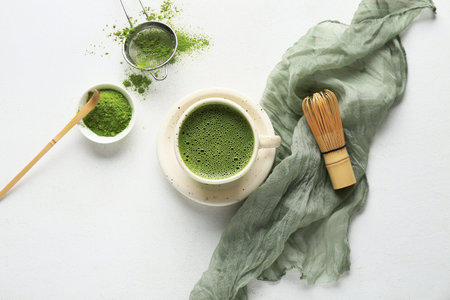 Composition with napkin, bowl of matcha tea and powder on white background