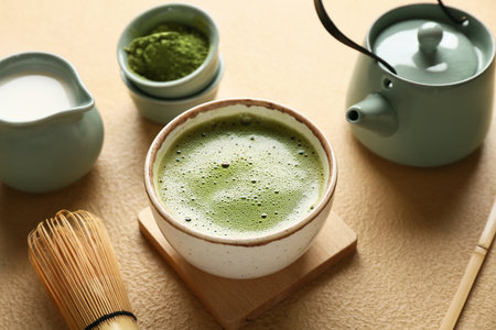 Composition with bowl of tasty matcha tea on beige grunge background, closeupの写真素材