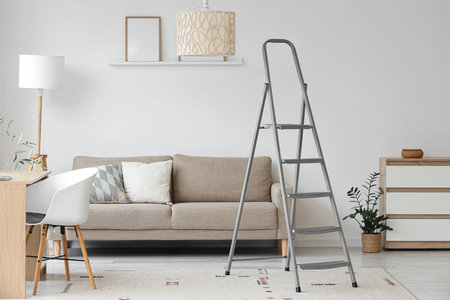 Interior of living room with stepladder, sofa and desk