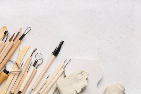Set of sculptor tools with plaster figure and clay on white grunge backgroundの写真素材