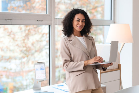 Young African-American businesswoman working with laptop in officeの写真素材