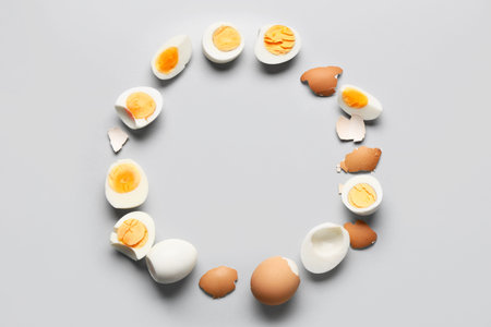 Frame made from tasty boiled eggs on gray background