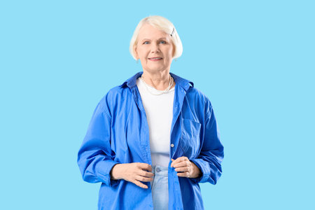 Senior woman in shirt on blue background