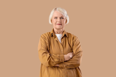Senior woman in shirt on beige background