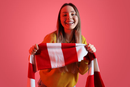 Female soccer fan with scarf on pink backgroundの写真素材