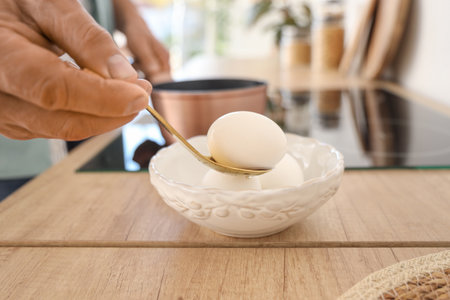 Mature man boiling eggs in kitchen, closeupの写真素材