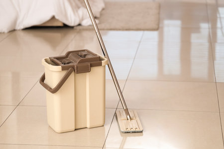 Mop with bucket on tile floor in bedroomの写真素材