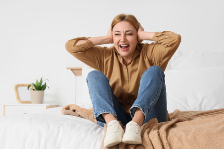 Mature woman sitting in bedroomの写真素材