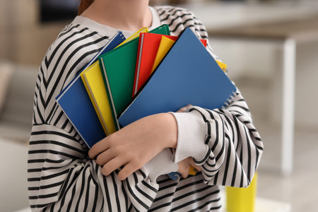 Teenage girl with different notebooks at home, closeupの写真素材