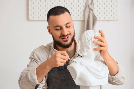 Male sculptor with bust in workshopの写真素材
