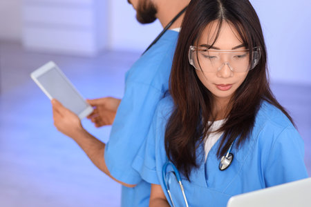 Female Asian doctor analyzing scientific data in laboratoryの写真素材