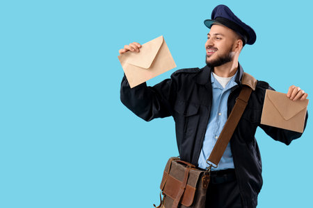 Handsome postman with letters on blue backgroundの写真素材