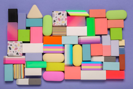 Many colorful rubber erasers on purple background