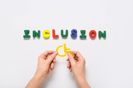 Inclusion word with wheelchair symbol and hands on white background, diversity and accessibility