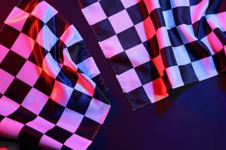 Racing flags on dark colorful background, closeup