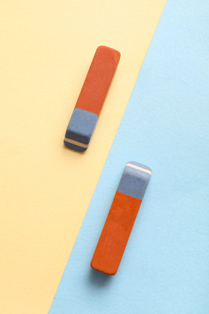 School erasers on color background
