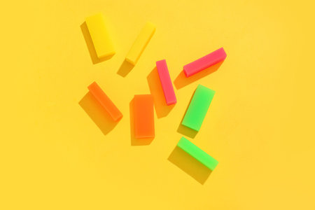 Different rubber erasers on yellow background