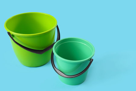 Green plastic buckets on blue background