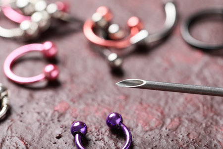 Body piercing and medical safety, hypodermic needle near jewelry accessories for professional studio procedure and hygiene standards in cosmetic clinic