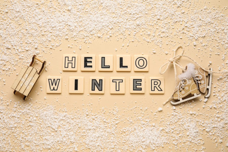 Composition with text HELLO WINTER, decorative sleigh and skates on beige background, closeup