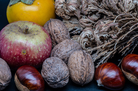 A composition of typically autumnal fruits such as chestnuts, walnuts, persimmons or the apple,...