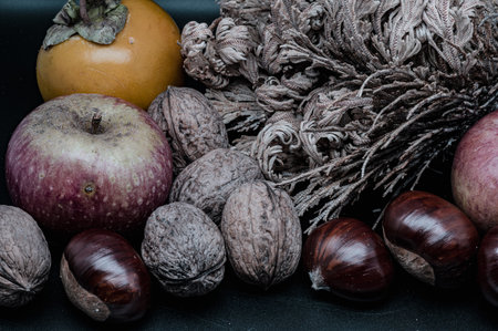 A composition of typically autumnal fruits such as chestnuts, walnuts, persimmons or the Campanian Annurca apple, enhancing their beauty and detail.の写真素材