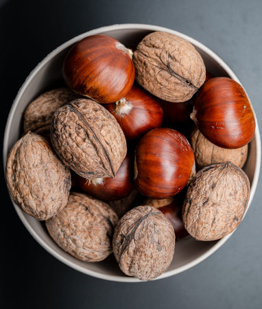 A composition of typically autumnal fruits such as chestnuts and walnuts, enhancing their beauty and...
