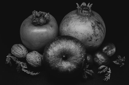A composition of typically autumnal fruits such as chestnuts, walnuts, persimmons or the Campanian Annurca apple, enhancing their beauty and detail.の写真素材
