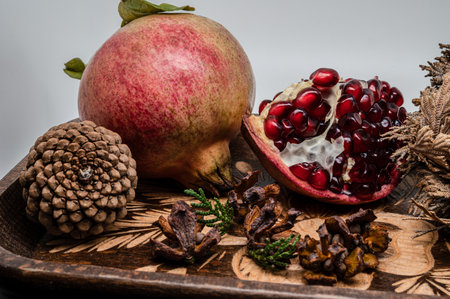 The pomegranate is the fruit of the pomegranate tree (Punica granatum), a spherical, deep red berry with a thick skin that encloses numerous juicy seeds (arils).の写真素材