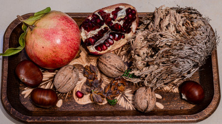 The pomegranate is the fruit of the pomegranate tree (Punica granatum), a spherical, deep red berry with a thick skin that encloses numerous juicy seeds (arils).の写真素材
