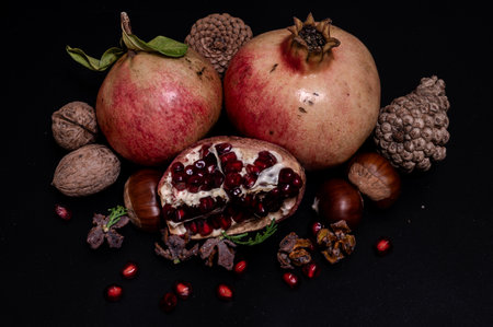 The pomegranate is the fruit of the pomegranate tree (Punica granatum), a spherical, deep red berry with a thick skin that encloses numerous juicy seeds (arils).の写真素材