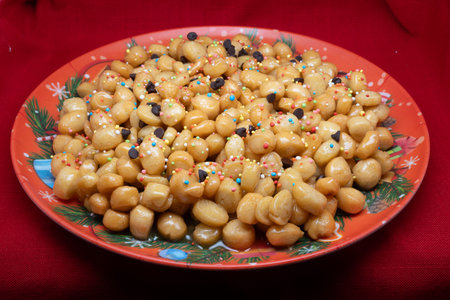 Struffoli are a typical dessert of the Neapolitan Christmas tradition, made up of small balls of sweet dough, fried and then covered in honey and colorful decorations.の写真素材