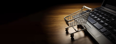 Online internet trading, modern marketing technology. Supermarket trolley near laptop keyboard. Dark background. AI generated. Business concept of global financial economy. Header banner mockup with copy space.の素材