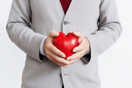 A young guy holds a heart in his hands, a symbol of health, love, white background isolate. Header banner mockup with copy space.の素材